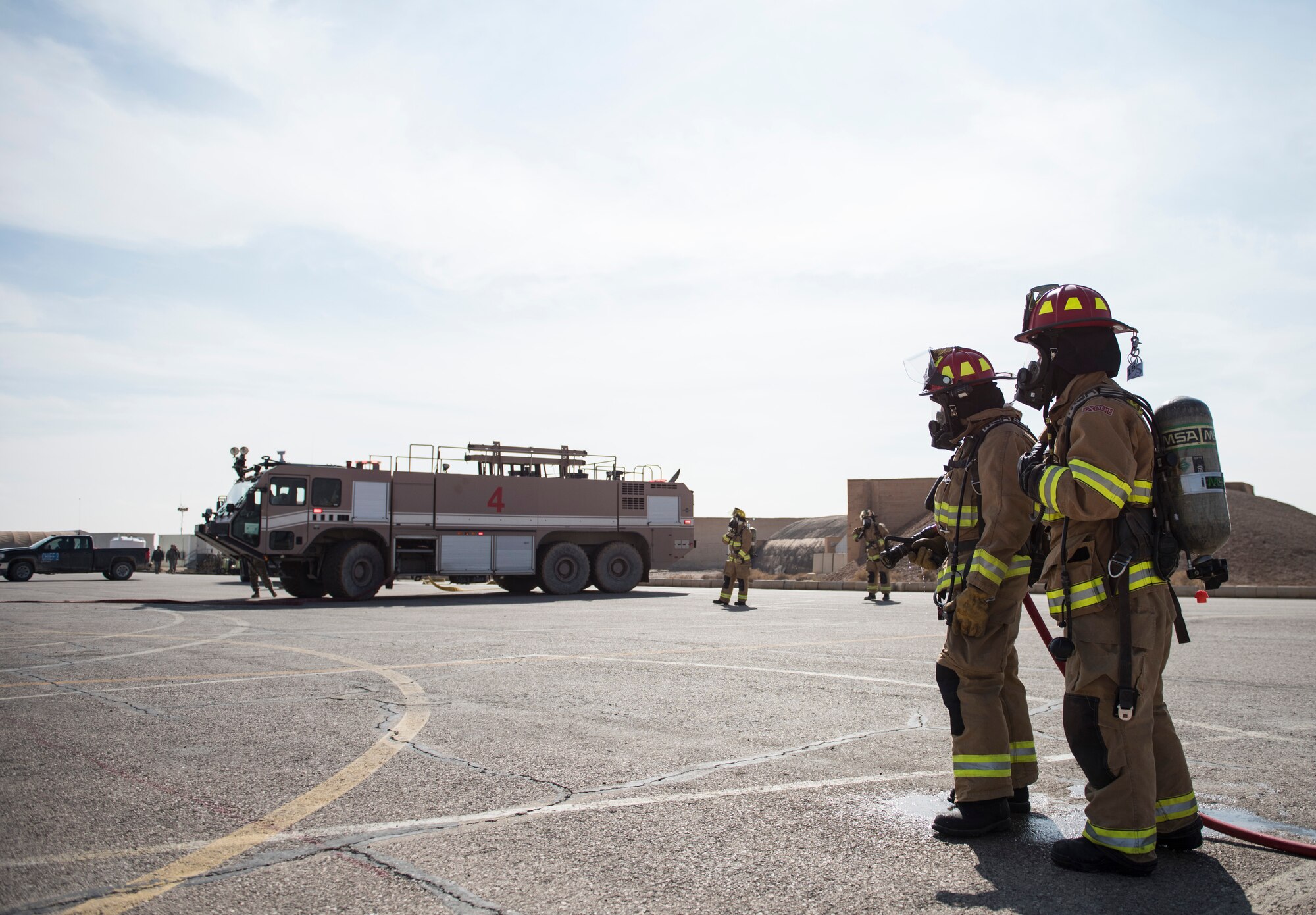 Firefighters assigned to the 332d Expeditionary Civil Engineer Squadron participate in an emergency aircraft egress training scenario February 14, 2018 in Southwest Asia. While three firefighters worked to evacuate an incapacitated pilot, their teammates established a safe perimeter and prepared for any possible escalations. (U.S. Air Force photo by Staff Sgt. Joshua Kleinholz)