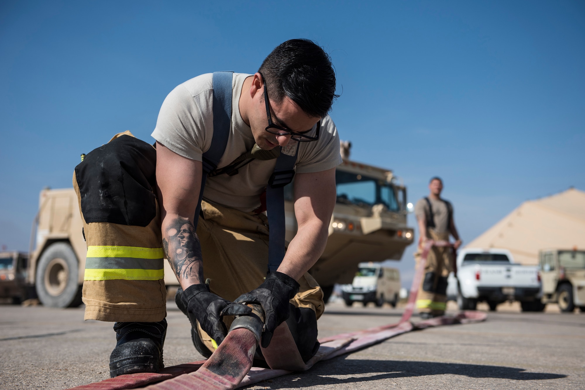 Staff Sgt. Keith Ryon, a firefighter assigned to the 332d Expeditionary Civil Engineer Squadron, prepares a hose during emergency egress training February 14, 2018 in Southwest Asia. Ryon, and the rest of the 332 CES fire protection flight, are deployed from the Kentucky Air National Guard. (U.S. Air Force photo by Staff Sgt. Joshua Kleinholz)