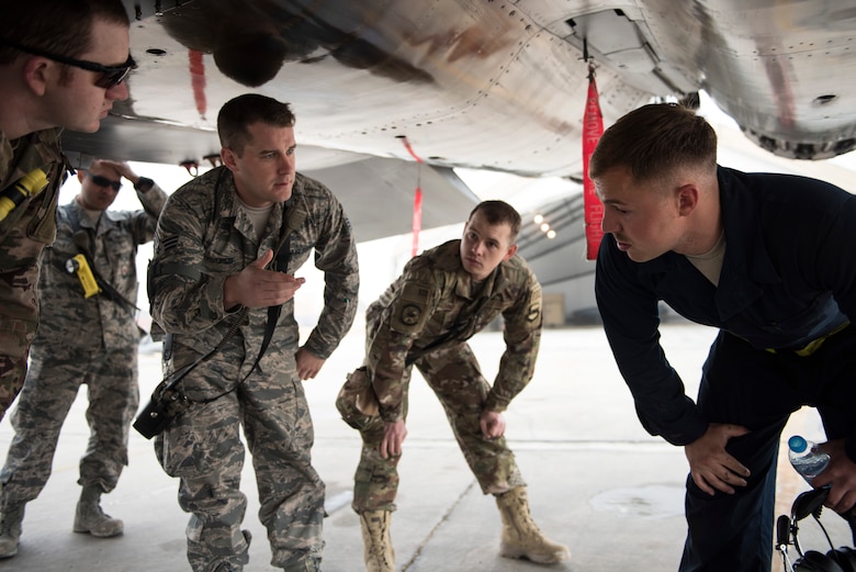 Staff Sgt. Schuler Edge, a crew chief assigned to the 332d Expeditionary Maintenance Squadron, briefs firefighters assigned to the 332d Expeditionary Civil Engineer Squadron on the safe operation of systems on the F-15E Strike Eagle prior to emergency egress training February 14, 2018 in Southwest Asia. Firefighters train to build familiarity with the aircraft based in their area of responsibility. (U.S. Air Force photo by Staff Sgt. Joshua Kleinholz)