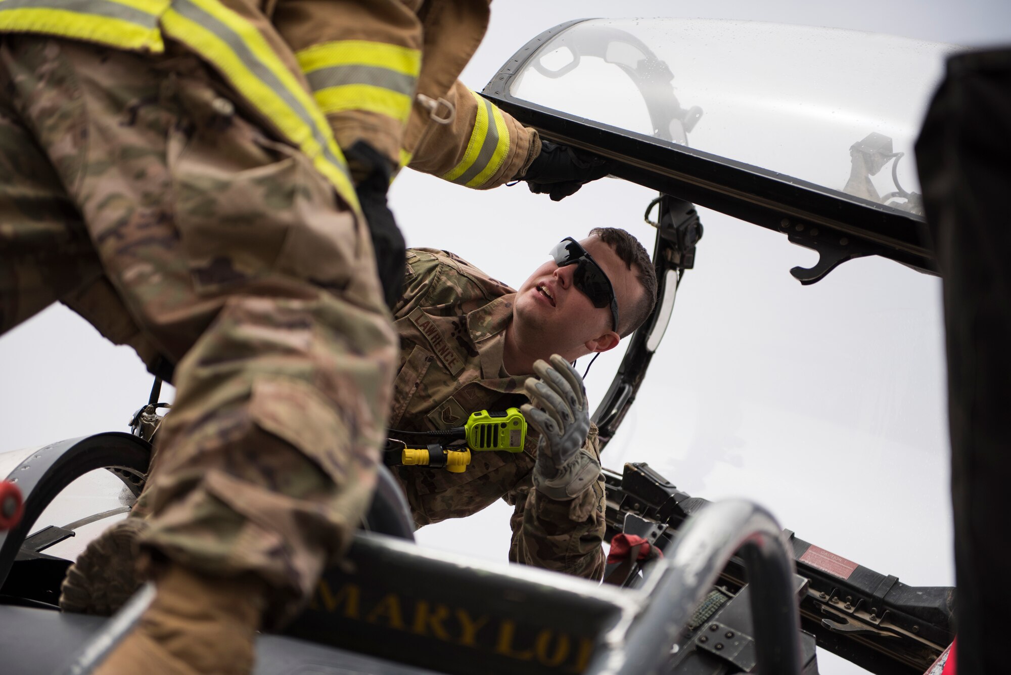 Staff Sgt. Derrick Lawrence, a firefighter assigned to the 332d Expeditionary Civil Engineer Squadron, discusses response strategies with a teammate during F-15E Strike Eagle emergency egress training February 14, 2018 in Southwest Asia. The exercise tested the team’s ability to respond to an aircraft mishap quickly and with a cohesive plan in place.  (U.S. Air Force photo by Staff Sgt. Joshua Kleinholz)