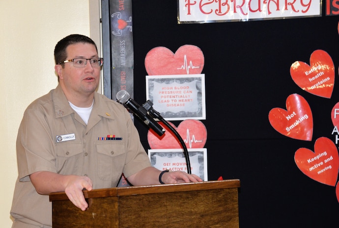Navy Lt. Ryan Connolly, a physician at Naval Health Clinic Charleston, describes symptoms of, and ways to mitigate, heart disease, the No. 1 killer of women and men, during NHCC’s Heart Health Month observance Feb. 2, which was also National Wear Red Day, a campaign event to raise awareness about heart disease -- the No. 1 killer of women and men. Naval Health Clinic Charleston staff members wore red attire and ribbons, snacked on heart-healthy treats and listened to Connolly, as he described symptoms of, and ways to mitigate, heart disease.