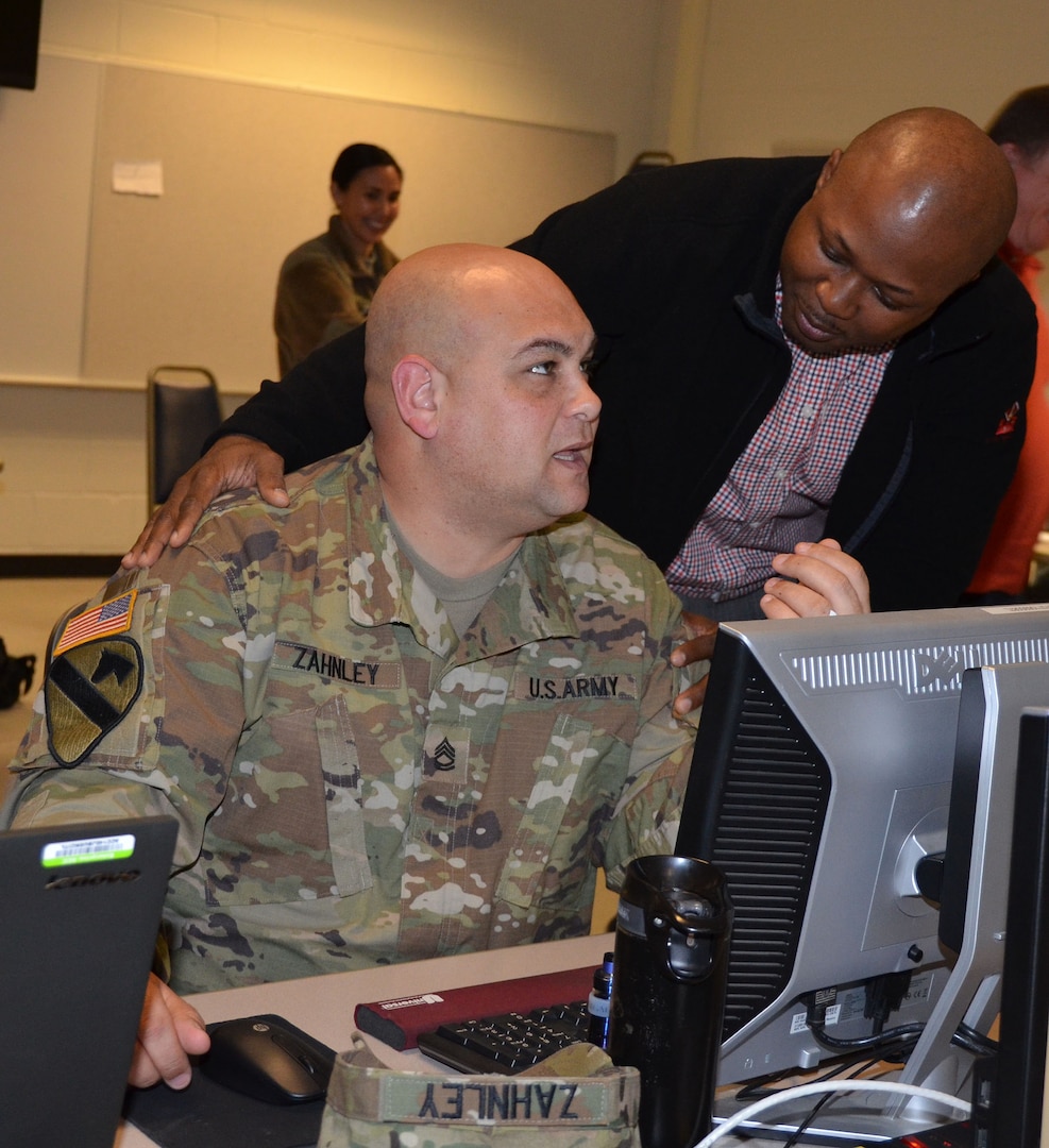 Role playing as a local vendor, Chief Warrant Officer 3 Kortney Johnson (right) seeks favor in a contract award from Sgt. 1st Class Jason Zahnley (left) during a humanitarian assistance disaster relief exercise Feb. 8 at Joint Base San Antonio-Camp Bullis. Zahnley is the NCO in charge of the 677th Contracting Team and Johnson is the property book officer for the 410th Contracting Support Brigade at JBSA-Fort Sam Houston.