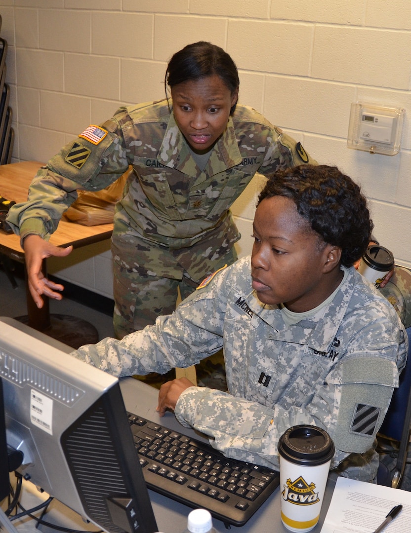 Maj. Randalle Carter (left) and Capt. Missy McNeill (right) discuss contracting support during a humanitarian assistance disaster relief exercise Feb. 8 at Joint Base San Antonio-Camp Bullis. Carter is an operations officer who led the exercise and McNeill is a contract management officer. Both are from the 410th Contracting Support Brigade at JBSA-Fort Sam Houston.