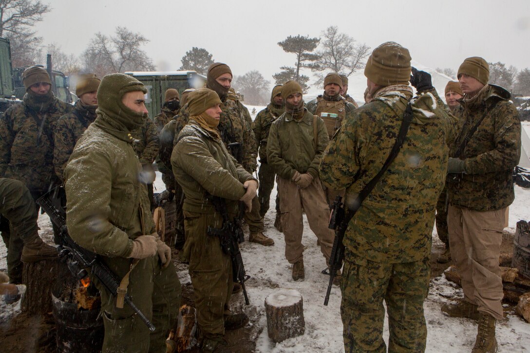 Capt. Andrew Bender (right), commanding officer of Company F, 4th Tank Battalion, 4th Marine Division, speaks to Marines about the final training days of Winter Break 2018, aboard Camp Grayling, Michigan, Feb. 11, 2018. Fox Co., 4th Tank Bn., conducted exercise Winter Break 18 to take advantage of Camp Grayling's frozen, wintery climate and test their offensive, defensive and maneuver capabilities in any austere cold weather environment.
