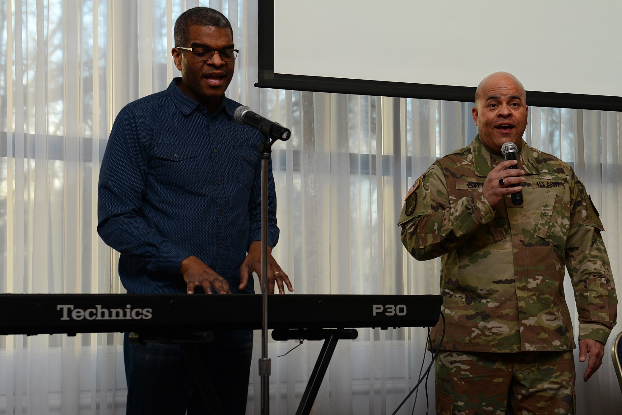 U.S. Army Sgt. 1st Class Dale Lopez, Joint Base Langley-Eustis senior religious affairs NCO, and Dave Gholson, Bethel Temple Church pastor in Hampton, Va., perform a song in English and Spanish during the National Prayer Breakfast at JBLE, Va., Feb. 7, 2018.