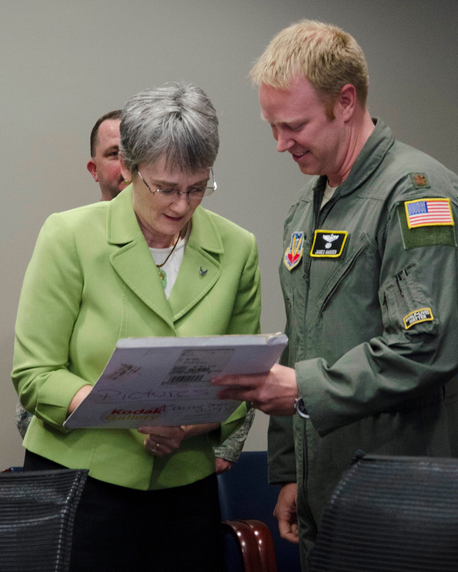Maj. James A. Hansen II, director of operations, Air Force Technical Applications Center, Patrick AFB, Fla., watches as Secretary of the Air Force Heather Wilson autographs a photo from Hansen’s U.S. Air Force Academy graduation ceremony.  Wilson sponsored Hansen when she was a U.S. representative for the state of New Mexico, and was pictured in the photo with Hansen and President George W. Bush.  (U.S. Air Force photo by Susan A. Romano)
