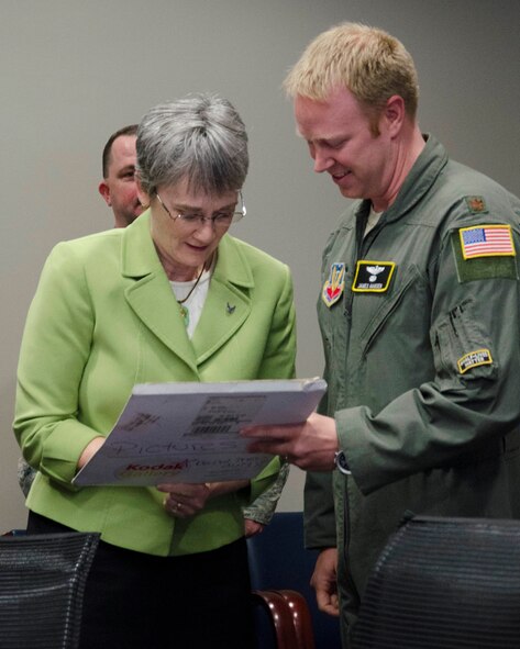 Maj. James A. Hansen II, director of operations, Air Force Technical Applications Center, Patrick AFB, Fla., watches as Secretary of the Air Force Heather Wilson autographs a photo from Hansen’s U.S. Air Force Academy graduation ceremony.  Wilson sponsored Hansen when she was a U.S. representative for the state of New Mexico, and was pictured in the photo with Hansen and President George W. Bush.  (U.S. Air Force photo by Susan A. Romano)