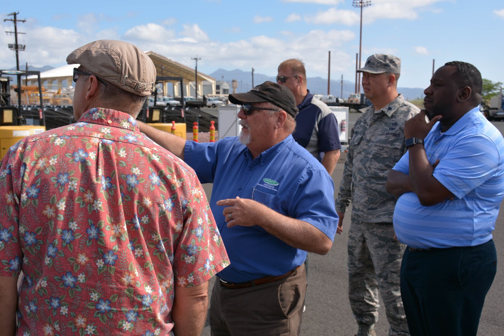 Man at center briefs group standing around him