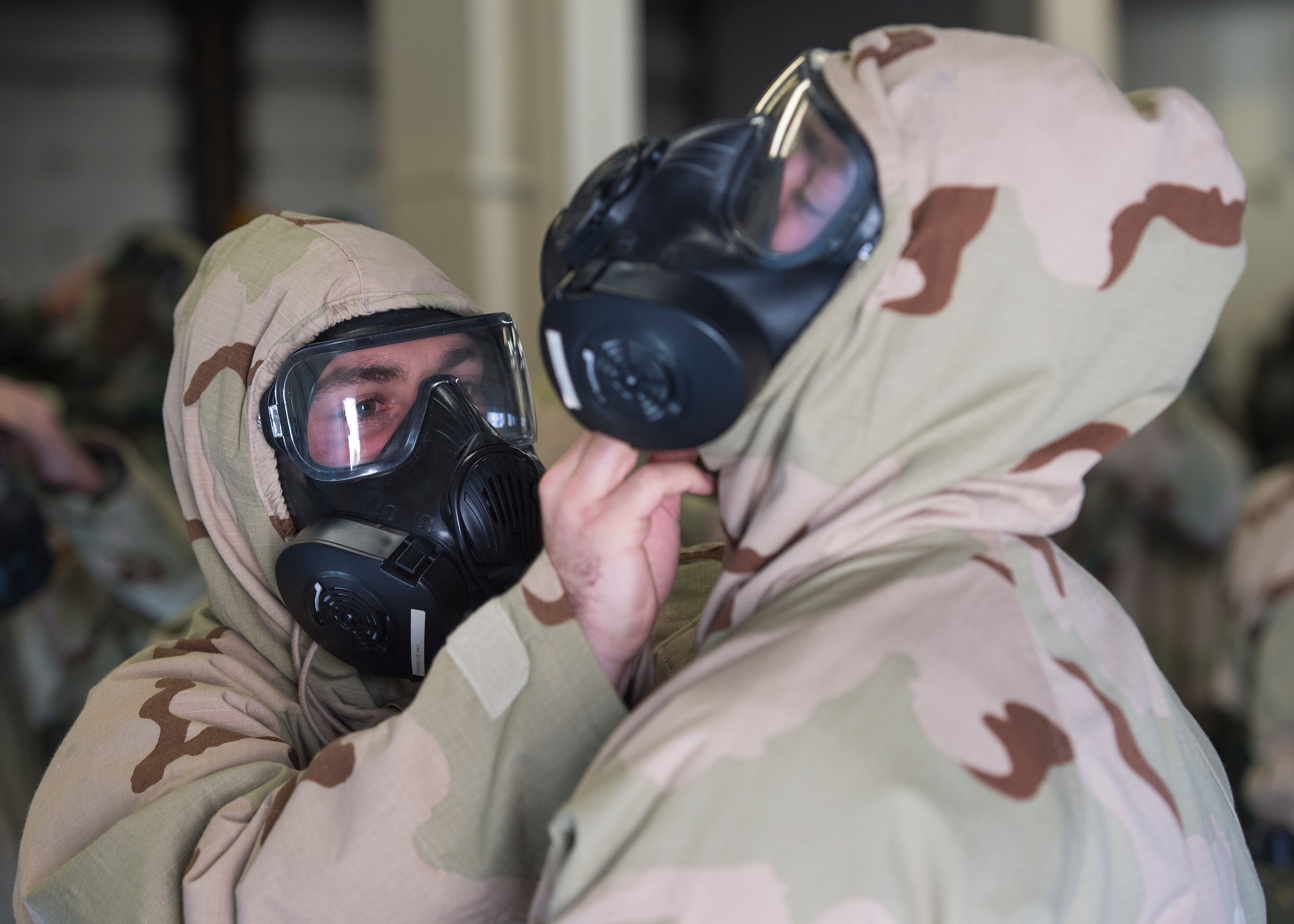 U.S. Air Force Airmen, assigned to the 633rd Civil Engineer Squadron, inspect their Joint Service Lightweight Integrated Suit Technology during Prime Base Engineer Emergency Force day training at Joint Base Langley-Eustis, Virginia, Jan. 25, 2018.