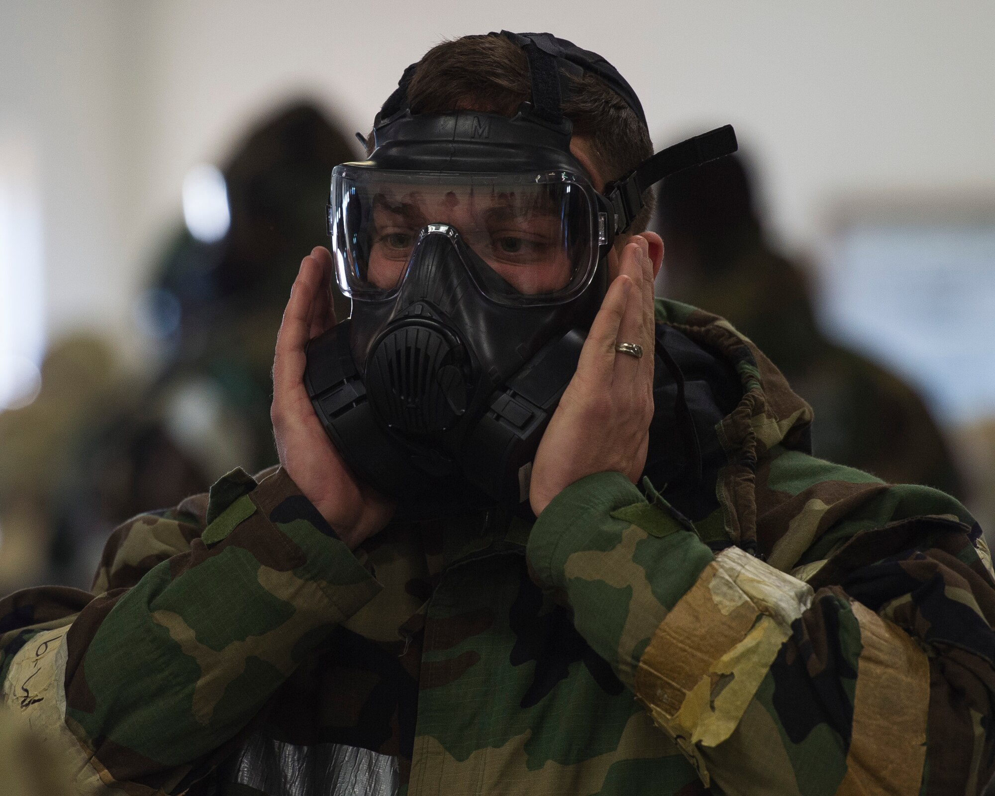 A U.S. Air Force Airman, assigned to the 633rd Civil Engineer Squadron, inspects the seal on his M50 joint service general purpose mask during Prime Base Engineer Emergency Force day training at Joint Base Langley-Eustis, Virginia, Jan. 25, 2018.