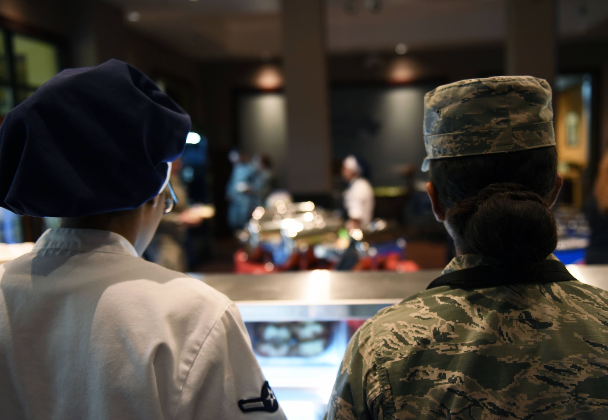 Airman Melanie Moore, 60th Force Support Squadron food service specialist, and Airman Domonique Jordan, 60th FSS food service apprentice, man the Dining Facility serving line Feb. 11 at Travis Air Force Base, Calif. Moore and Jordan are typically the first people diners see when arriving at the DFAC and handle much of the customer interaction for the operation.