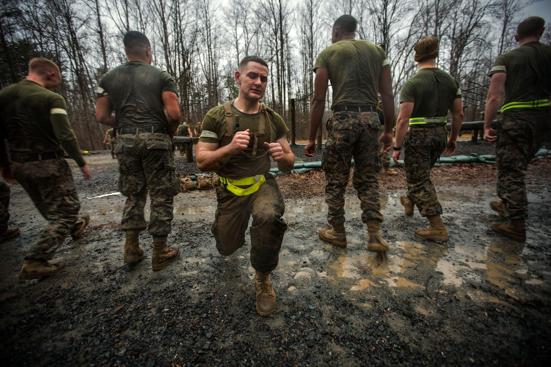 A Marine lunges outside while five others stand behind him facing the reverse direction.