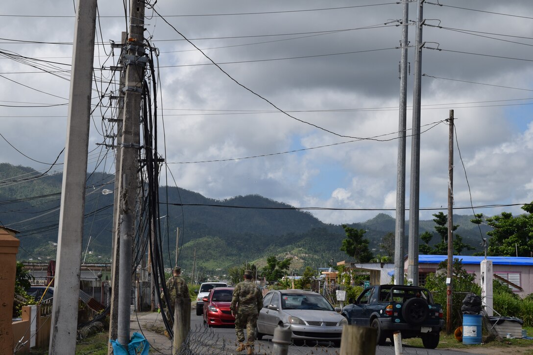 USACE Task Force Power Restoration Commander Col. John P. Lloyd (foreground) and TF Power Operations Officer Capt. Aaron Anderson survey the damage wrought by Hurricane Maria as they walk through a neighborhood in Maunabo, Puerto Rico, on Jan. 3. To date, Anderson’s team has set-up microgrids in five locations, starting with Culebra Island. The next four were placed in the Southeast, which was ground zero, sustaining tremendous damage when Hurricane Maria made landfall. These microgrids are operating in Patillas, Maunabo, Naguabo and Yabucoa, Puerto Rico.