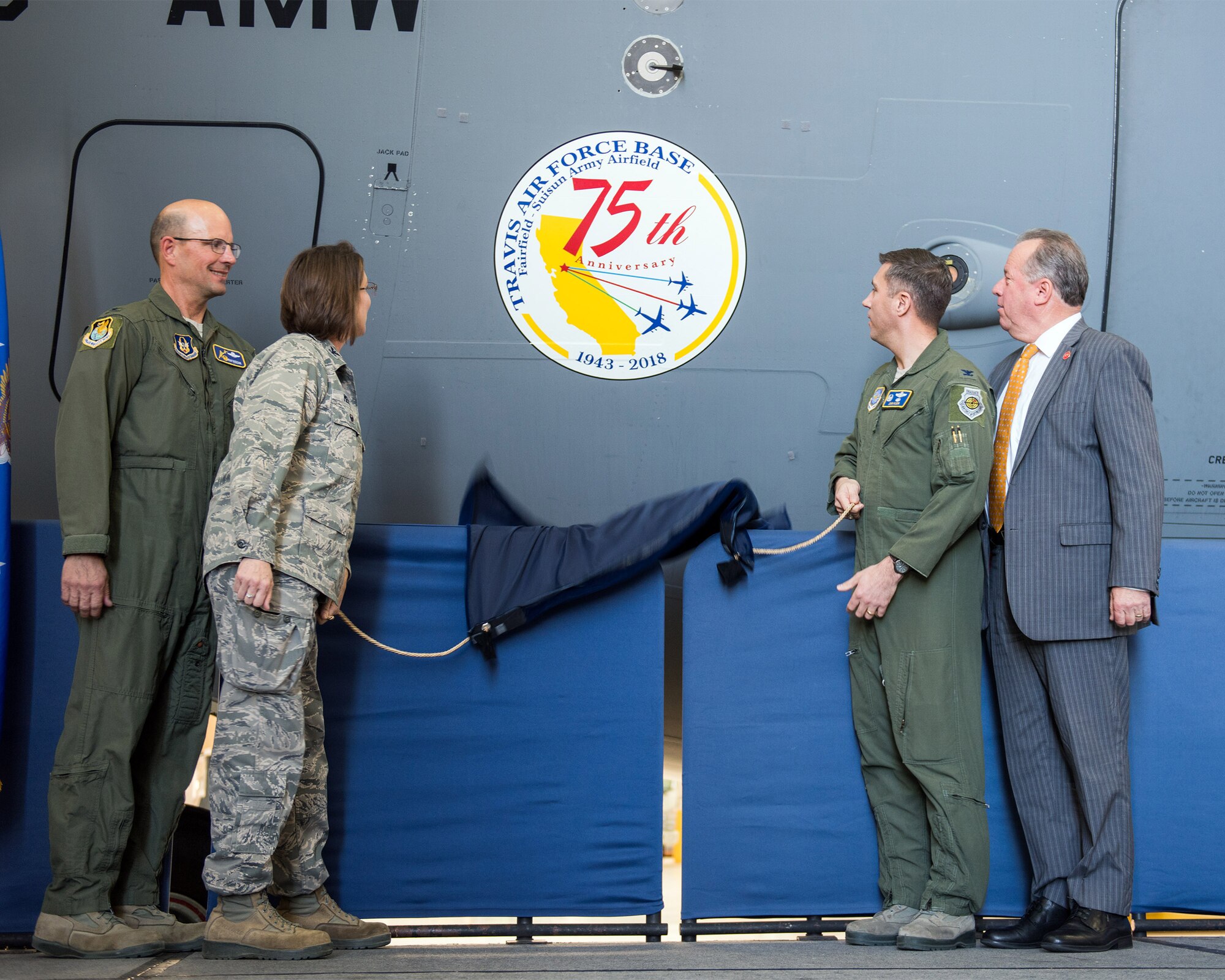 From left, U.S. Air Force Col. Raymond Kozak, 349th Air Mobility Wing commander, Col. Ruth Meyer, 621st Contingency Resonse Wing, Col. John Klein, 60th Air Mobility Wing commander, and State Senator Bill Dodd (D-Napa), 3rd Senate District, reveal the 75th Anniversary logo during a ceremony at Travis Air Force Base, Calif., Feb. 8, 2018. Travis is celebrating 75 years as a major strategic logistics hub for the Pacific and integral part of global power projection for the total force. (U.S. Air Force photo by Louis Briscese)
