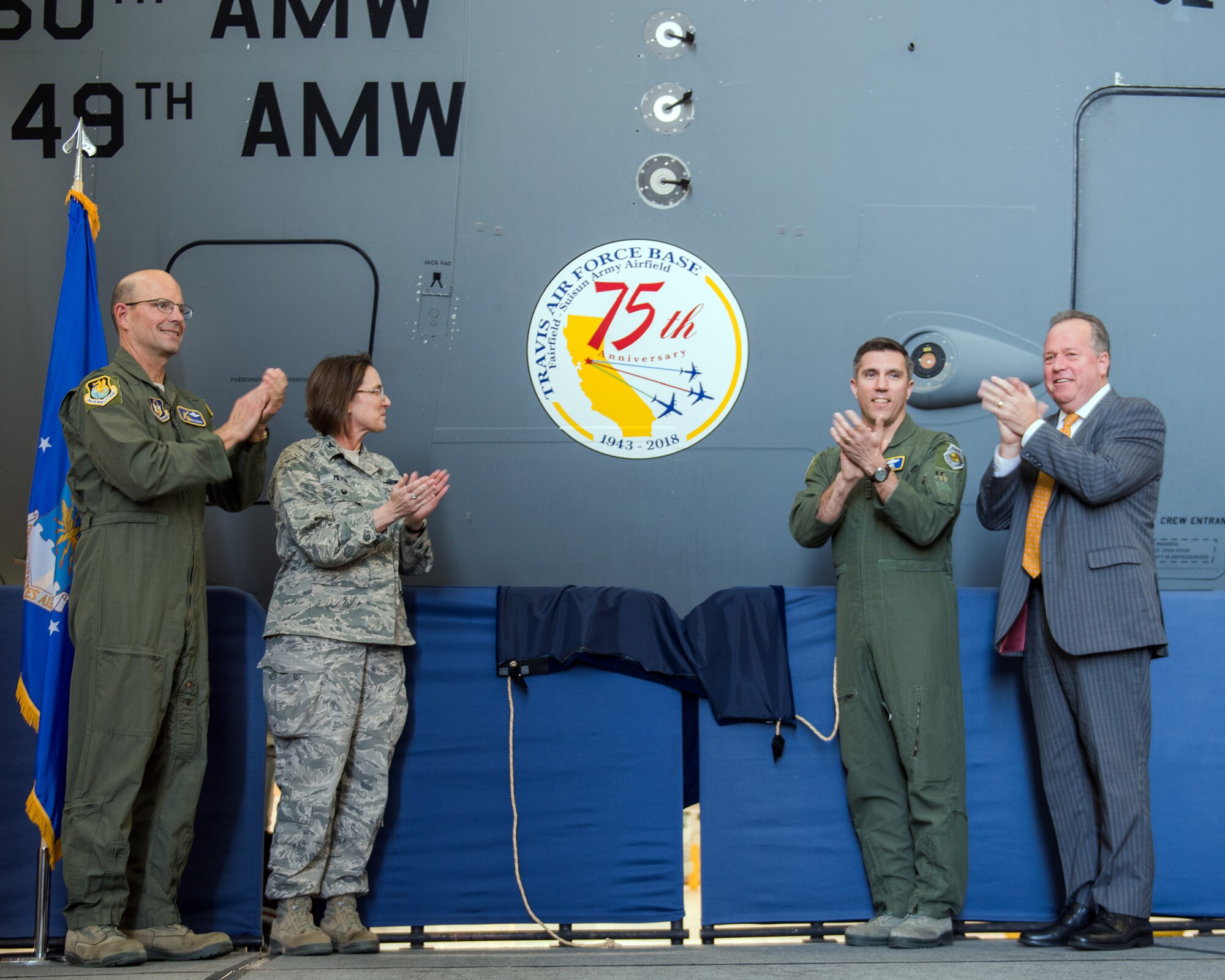 From left, U.S. Air Force Col. Raymond Kozak, 349th Air Mobility Wing commander, Col. Ruth Meyer, 621st Contingency Resonse Wing, Col. John Klein, 60th Air Mobility Wing commander, and State Senator Bill Dodd (D-Napa), 3rd Senate District, reveal the 75th Anniversary logo during a ceremony at Travis Air Force Base, Calif., Feb. 8, 2018. Travis is celebrating 75 years as a major strategic logistics hub for the Pacific and integral part of global power projection for the total force. (U.S. Air Force photo by Louis Briscese)