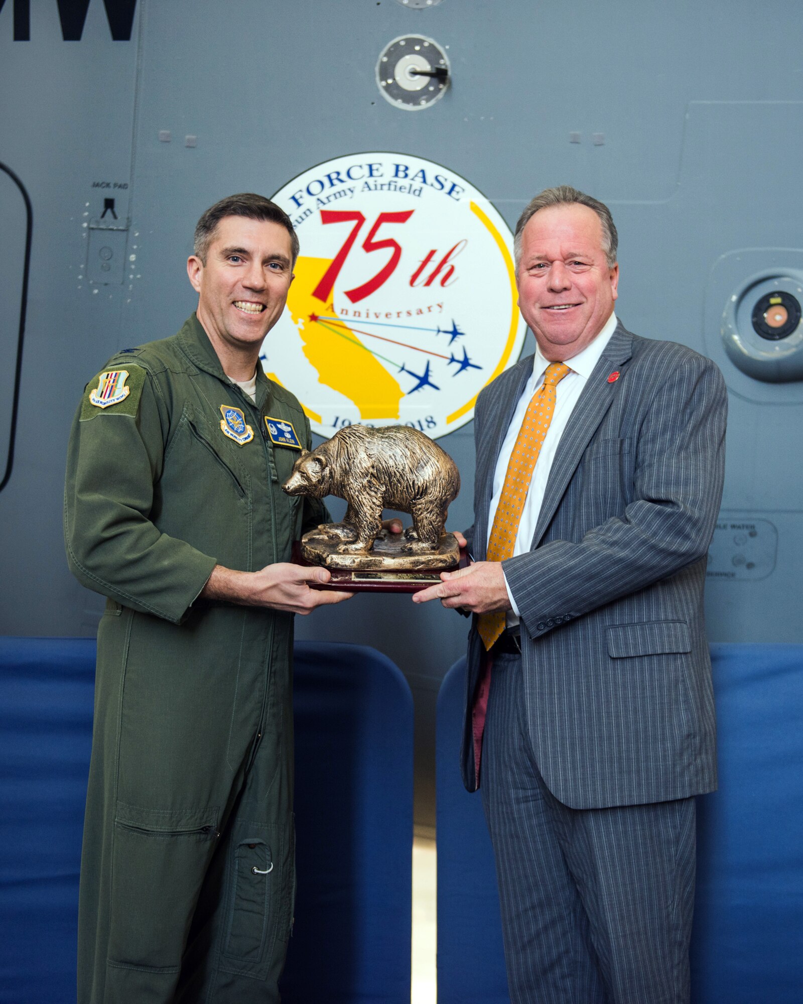 U.S. Air Force Col. John Klein, 60th Air Mobility Wing commander, presents State Senator Bill Dodd (D-Napa), 3rd Senate District, with a Golden Bear during the 75th Anniversary kickoff celebration at Travis Air Force Base, Calif., Feb. 8, 2018. The celebration featured the inaugural unveiling of the 75th Anniversary logo on a C-17 Globemaster III. Travis is celebrating 75 years as a major strategic logistics hub for the Pacific and integral part of global power projection for the total force. (U.S. Air Force photo by Louis Briscese)