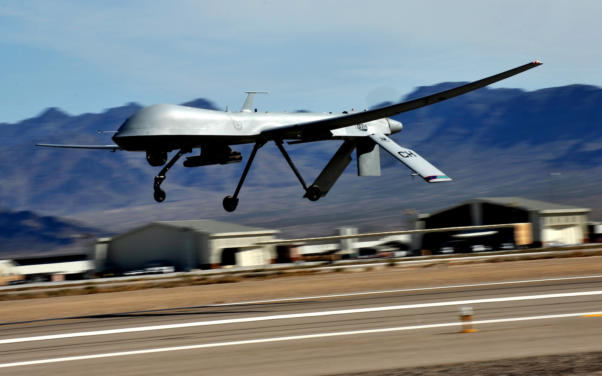 An MQ-1 Predator flies above the flight line during launch and recovery training at Creech Air Force Base, Nevada March 14, 2015. The weaponizing of Predator by Bill Grimes’ Big Safari team is credited with changing the way air wars are fought. (U.S. Air Force photo/Senior Master Sgt. Cecilio Ricardo)