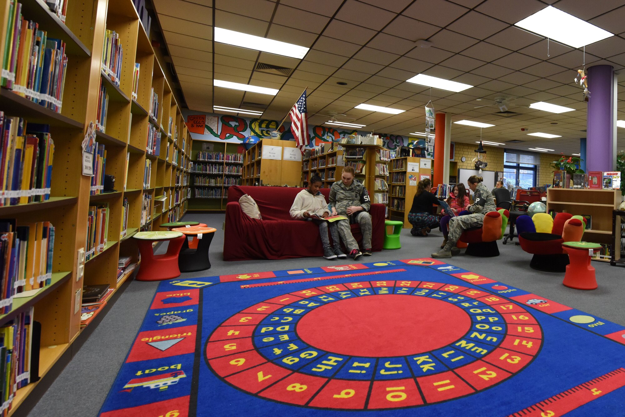 Airman 1st Class Clare Hilborn, 569th United States Force Police Squadron police service personnel, and Senior Airman Rachel Newell, 569th USFPS standards and evaluation personnel, read with children on Feb. 6, 2018 at Vogelweh Elementary School on Vogelweh Military Complex, Germany. Due to the popular demand of this program, volunteers will read with children once per week this year compared to once per month last year.
