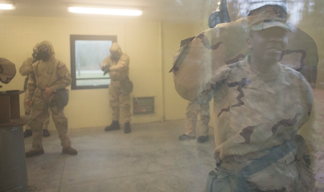 Petty Officer 3rd Class Herbert Peterson, corpsman, 3rd platoon, Charlie Co., Fleet Anti-terrorism Security Team, U.S. Marine Corps Security Forces Regiment, looks in a window at Marines from various FAST units conducting a protective mask verification exercise, aboard Naval Weapons Station Yorktown, Va., Feb. 14. Marines were exposed to 2-chlorobenzalmalononitrile, or CS gas, which caused irritation in the mucus membranes resulting in watery eyes, coughing, and other symptoms. (Official U.S. Marine Corps photo by Chris Jones/Released)