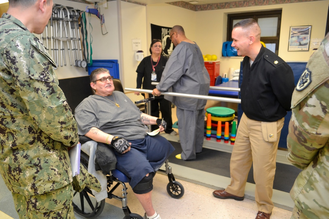Navy Lt. Cmdr. Isaac Ortman laughs with a patient receiving physical therapy at the Corporal Michael J. Crescenz Veterans Affairs Medical Center, Feb. 12, 2018 in Philadelphia.