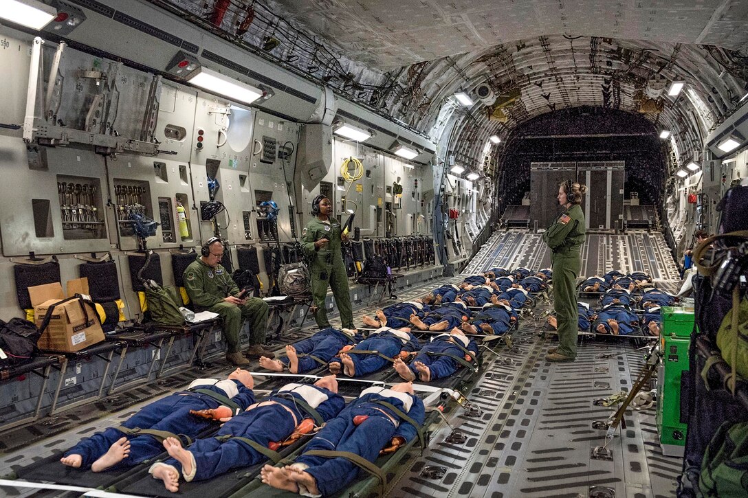 Airmen discuss patient treatment during an in-flight aeromedical evacuation training exercise.