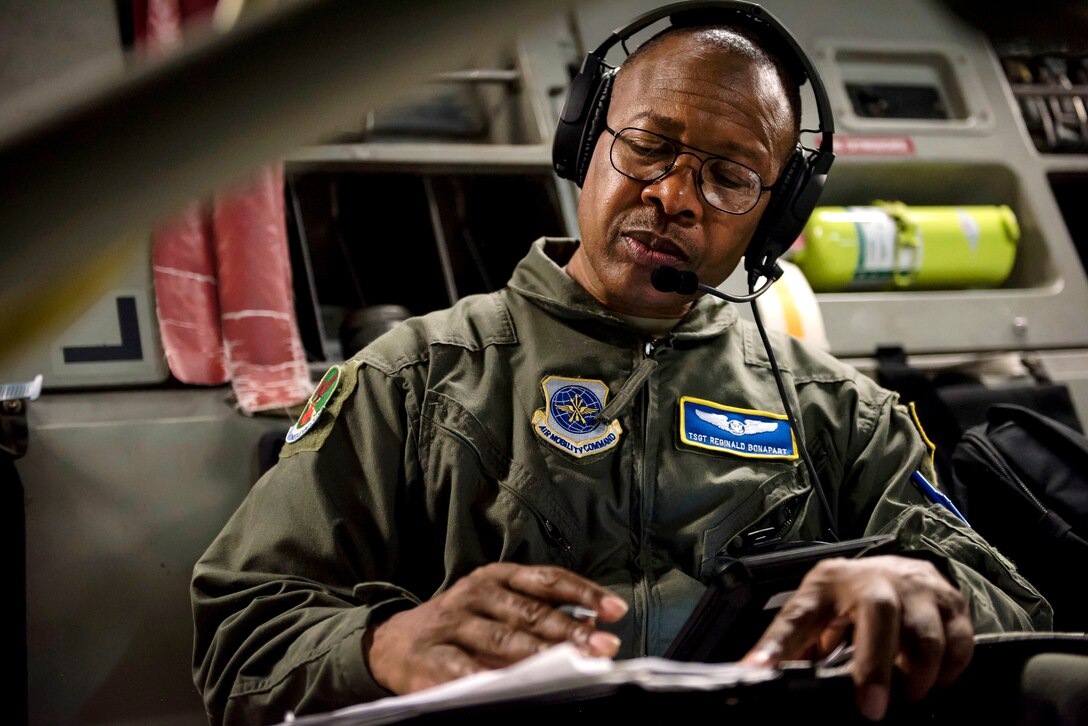 Air Force Tech. Sgt. Reginald Bonapart completes patient treatment records during an in-flight aeromedical evacuation training exercise.