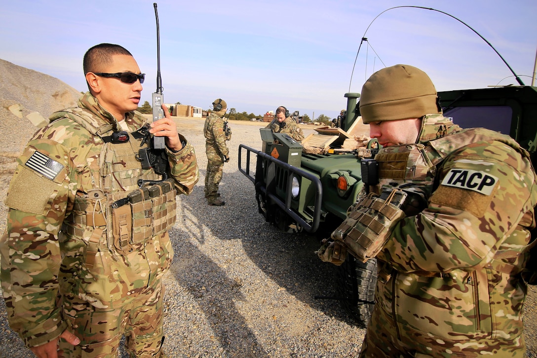 Air Force Senior Airman Victor Dulay, left, coordinates with his team members on the radio.