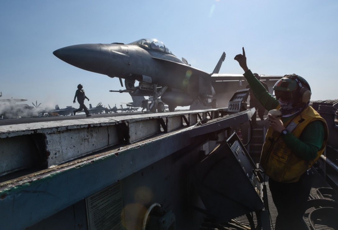 An aircraft prepares to launch on the USS Theodore Roosevelt's flight deck.