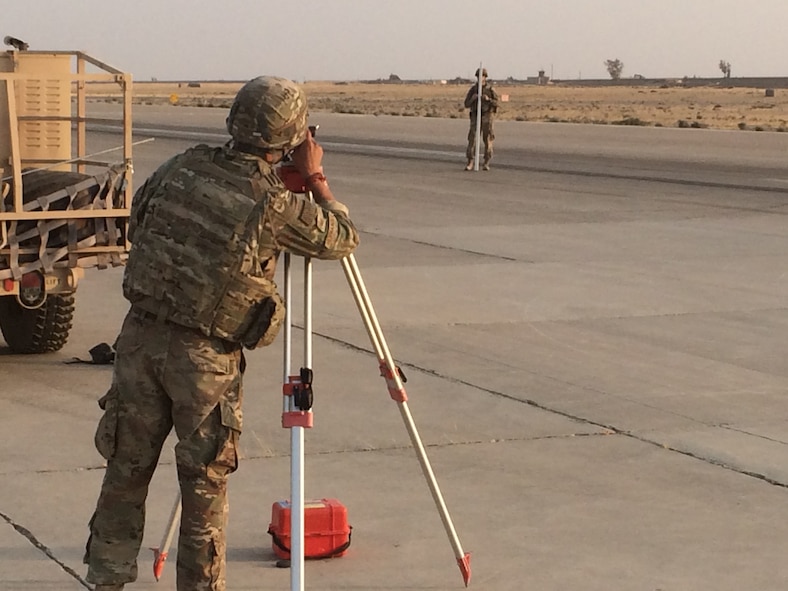 TSgt Ruben Hernandez (forefront) and Capt Miles Ryan (background) are surveying the extent of a depression in a runway in Qayyarah-West, Iraq.