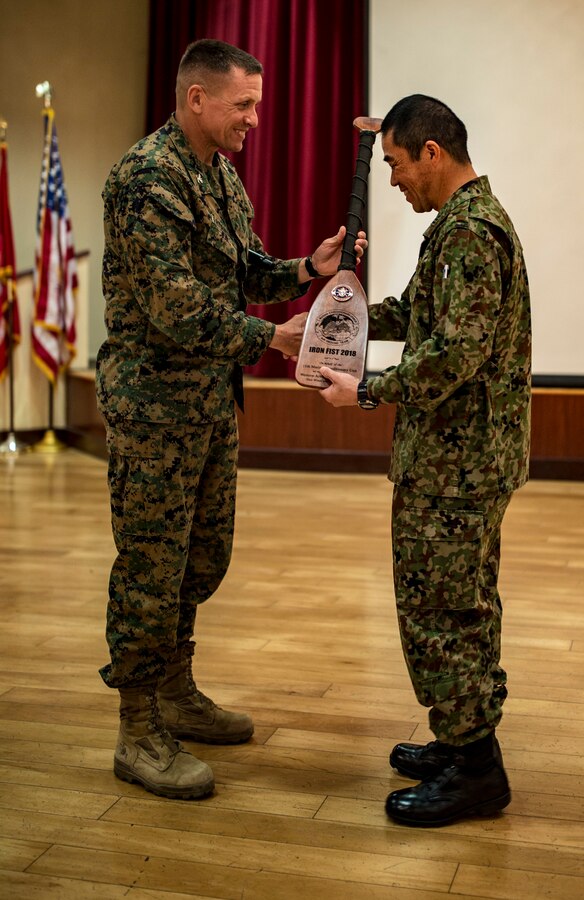 MARINE CORPS BASE CAMP PENDLETON, Calif - Col. Fridrik Fridriksson, commanding officer of the 11th Marine Expeditionary Unit, presents a oar as a gift to Col. Ryuki Toyota, the commanding officer of the Western Army Infantry Regiment, Japan Ground Self Defense Force during the closing ceremony of exercise Iron Fist 2018, Feb. 12. Iron Fist is an annual, bilateral training exercise where U.S. and Japanese service members train together and share techniques, tactics and procedures to improve their combined operational capabilities. (U.S. Marine Corps photo by Cpl. Jacob A. Farbo)