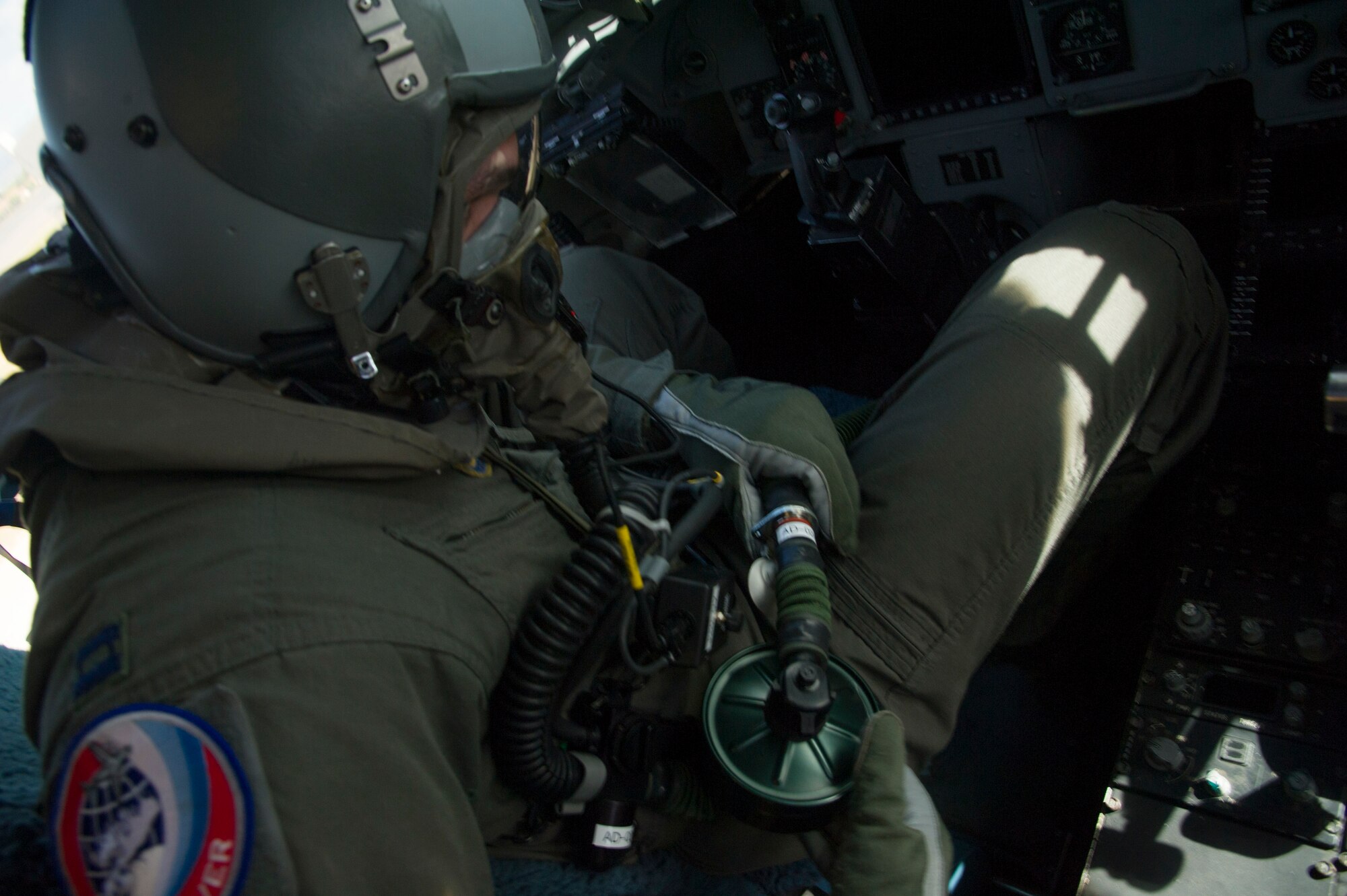 Capt. Justin Stanley, 535th Airlift Squadron C-17 Globemaster III pilot, connects his aircrew eye and respiratory protection system into the life support system on a C-17 at Joint Base Pearl Harbor-Hickam, Hawaii, Feb. 9, 2018. The 15th Wing routinely schedules protective gear training to ensure each Airman maintains professional readiness. (U.S. Air Force photo by Tech. Sgt. Heather Redman)