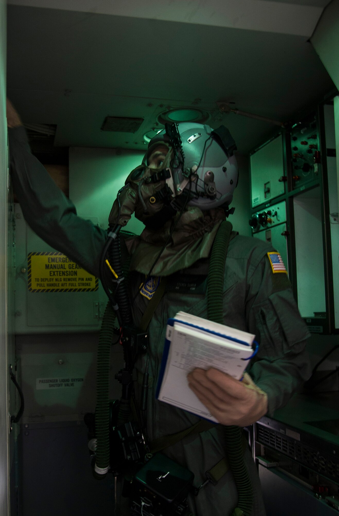 Airman 1st Class Steven Slover, 535th Airlift Squadron loadmaster, goes through his preflight checklist aboard a C-17 at Joint Base Pearl Harbor-Hickam, Hawaii, Feb. 9, 2018. Units across the joint base routinely schedule protective gear training to ensure all Airmen maintain professional readiness. (U.S. Air Force photo by Tech. Sgt. Heather Redman)