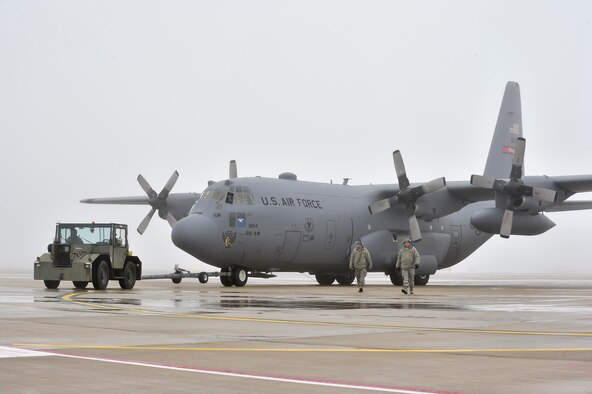 10th Aircraft Maintenance Squadron maintainers marshall a C-130H Hercules aircraft while it's being towed into a hangar here, Feb. 11, 2018.