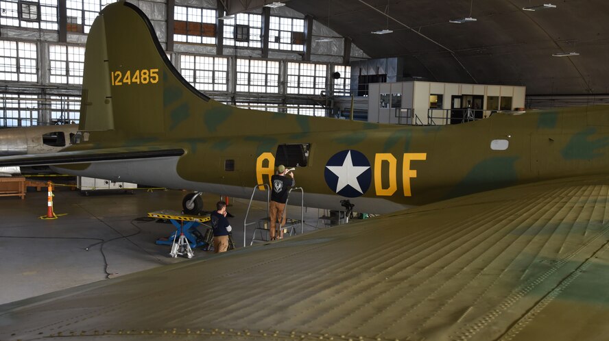 (01/25/2018) -- Museum restoration specialist Chad Vanhook paints the name 'Virginia' below the right waist gun position of the Boeing B-17F Memphis Belle as part of the aircraft restoration. (U.S. Air Force photo by Ken LaRock)