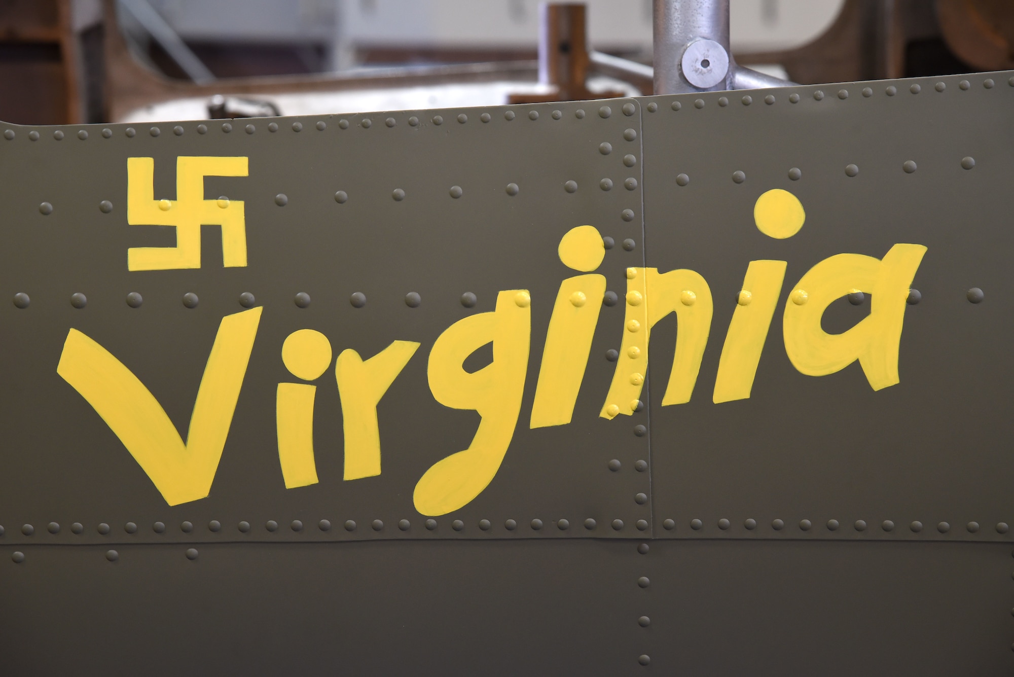 (01/25/2018) -- Museum restoration specialist Chad Vanhook paints the name 'Virginia' below the right waist gun position of the Boeing B-17F Memphis Belle as part of the aircraft restoration. (U.S. Air Force photo by Ken LaRock)