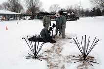 Airmen assigned to the 115th Fighter Wing Joint Interoperability Site Communications Capability package work together to erect a multiband antenna mast for the State Interoperable Mobile Communications Exercise (SIMCOM), in Fitchburg, Wis., Feb 7, 2018. The annual SIMCOM exercise tests the interoperability of federal, state and local emergency communications agencies. (U.S. Air National Guard photo by Tech. Sgt. Mary Greenwood)