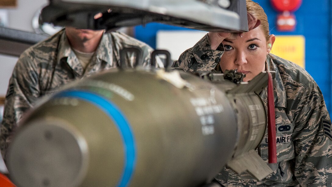 An airman watches as crews move an MK-82 into place.