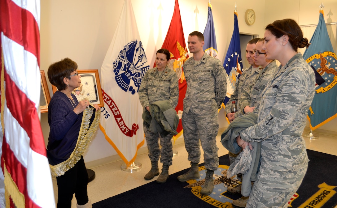 Hue Nguyen, left, DLA Troop Support flag room supervisor, explains the presidential flag manufacturing process to pharmacists of the Air Force Pharmacy Residency Program at DLA Troop Support, Feb. 7, 2018 in Philadelphia.