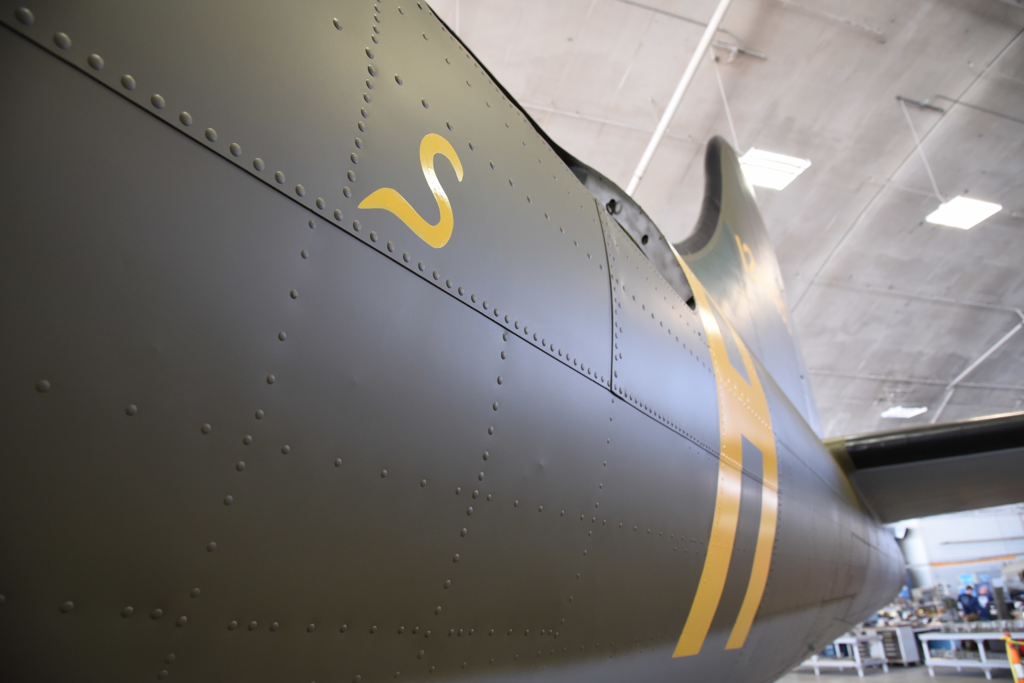 (01/25/2018) Museum restoration specialist Casey Simmons paints the letter 'S' for 'Sally' below the left waist gun position of the Boeing B-17F Memphis Belle as part of the aircraft restoration. Plans call for the aircraft to be placed on permanent public display in the WWII Gallery of the National Museum of the U.S. Air Force on May 17, 2018. (U.S. Air Force photo by Ken LaRock)