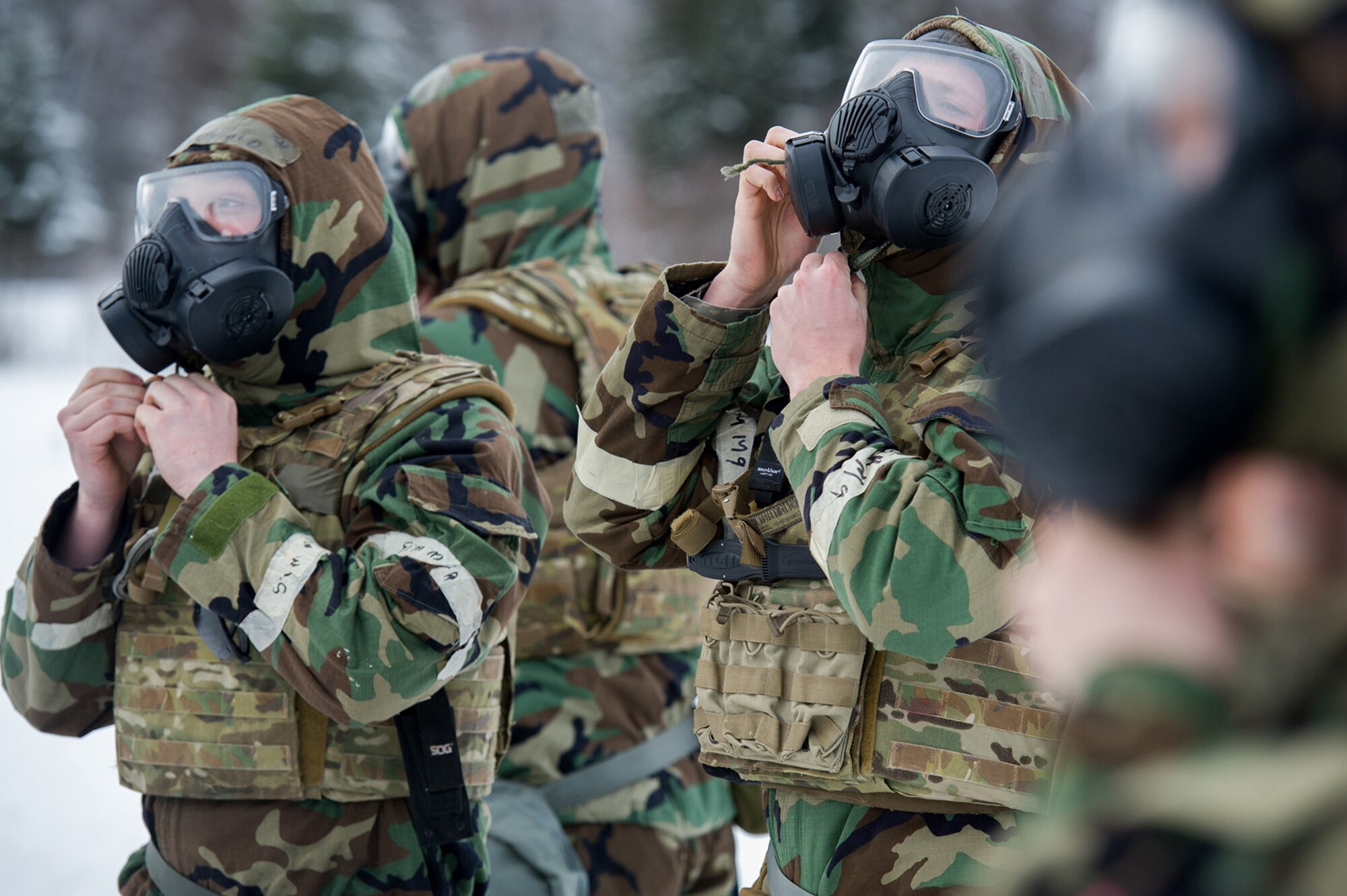 Airmen assigned to the 673d Civil Engineer Squadron, Explosives Ordinance Disposal Flight, don protective gear before a live-fire demolitions exercise in Mission Oriented Protective Posture 4 on Joint Base Elmendorf-Richardson, Alaska, Feb.14, 2018.  The Airmen were conducting EOD training in a simulated chemical weapons contaminated environment.