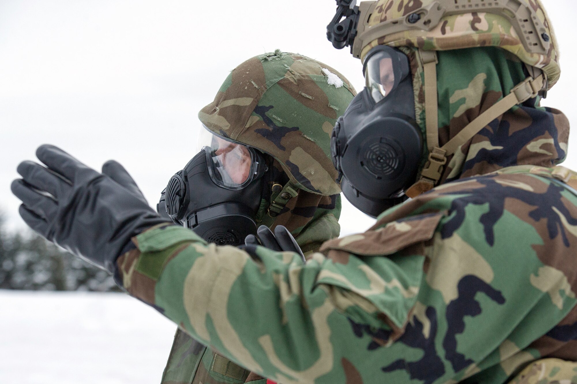 Airmen assigned to the 673d Civil Engineer Squadron, Explosives Ordinance Disposal Flight, observe preperations for a live-fire demolitions exercise in Mission Oriented Protective Posture 4 on Joint Base Elmendorf-Richardson, Alaska, Feb.14, 2018.  The Airmen were conducting EOD training in a simulated chemical weapons contaminated environment.