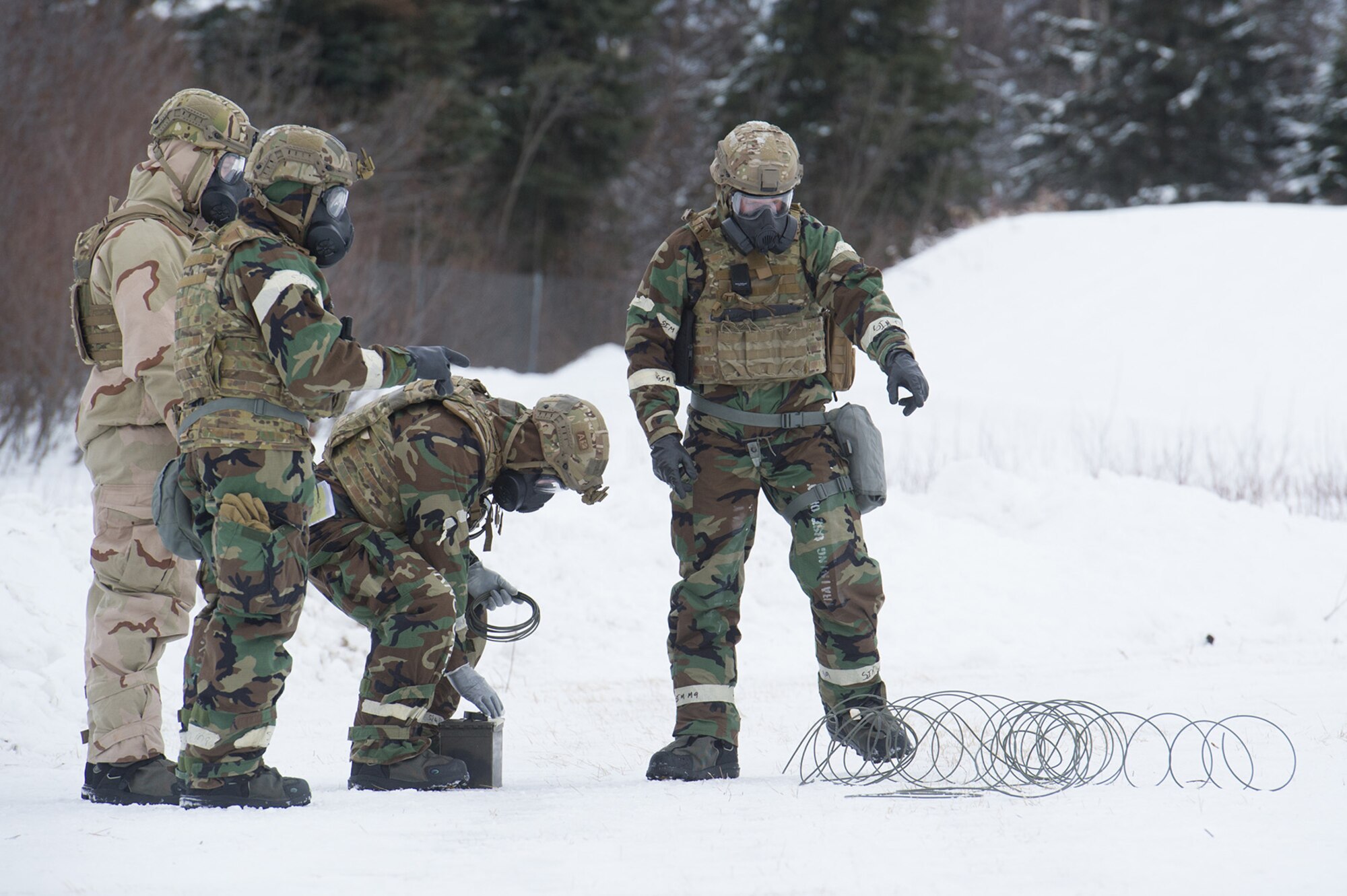 Airmen assigned to the 673d Civil Engineer Squadron, Explosives Ordinance Disposal Flight, conduct a live-fire demolitions exercise in Mission Oriented Protective Posture 4 on Joint Base Elmendorf-Richardson, Alaska, Feb.14, 2018.  The Airmen were conducting EOD training in a simulated chemical weapons contaminated environment.
