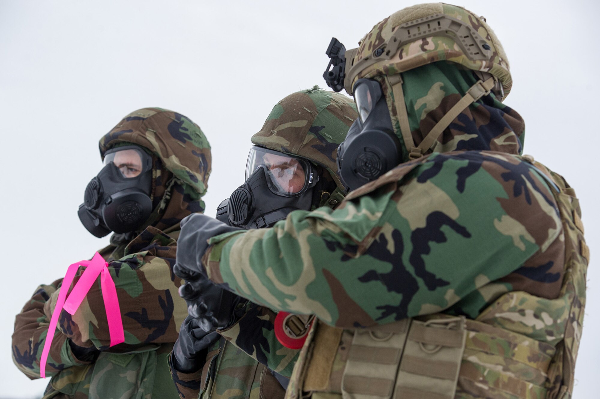 Airmen assigned to the 673d Civil Engineer Squadron, Explosives Ordinance Disposal Flight, observe preparations for a live-fire demolitions exercise in Mission Oriented Protective Posture 4 on Joint Base Elmendorf-Richardson, Alaska, Feb.14, 2018.  The Airmen were conducting EOD training in a simulated chemical weapons contaminated environment.