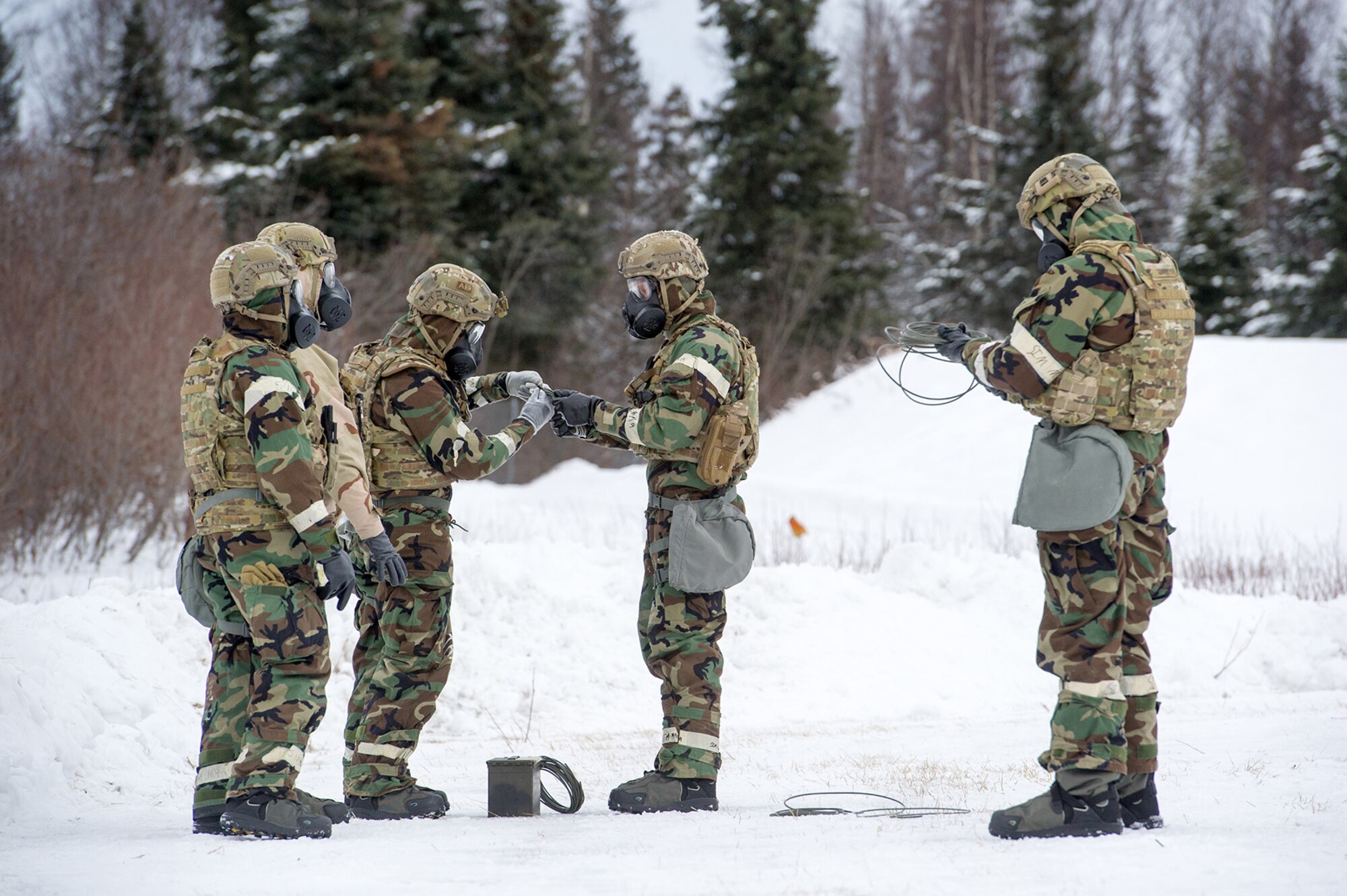 Airmen assigned to the 673d Civil Engineer Squadron, Explosives Ordinance Disposal Flight, prepare for a live-fire demolitions exercise in Mission Oriented Protective Posture 4 on Joint Base Elmendorf-Richardson, Alaska, Feb.14, 2018.  The Airmen were conducting EOD training in a simulated chemical weapons contaminated environment.