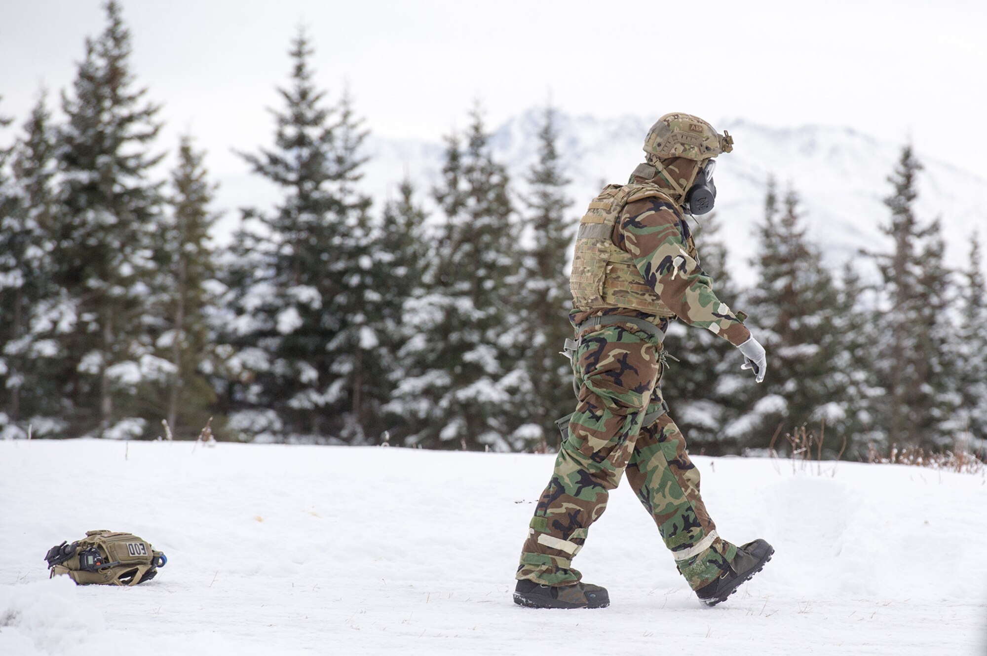 An Airman assigned to the 673d Civil Engineer Squadron, Explosives Ordinance Disposal Flight, walks on a live-fire demolitions range in Mission Oriented Protective Posture 4 on Joint Base Elmendorf-Richardson, Alaska, Feb.14, 2018.  The Airmen were conducting EOD training in a simulated chemical weapons contaminated environment.