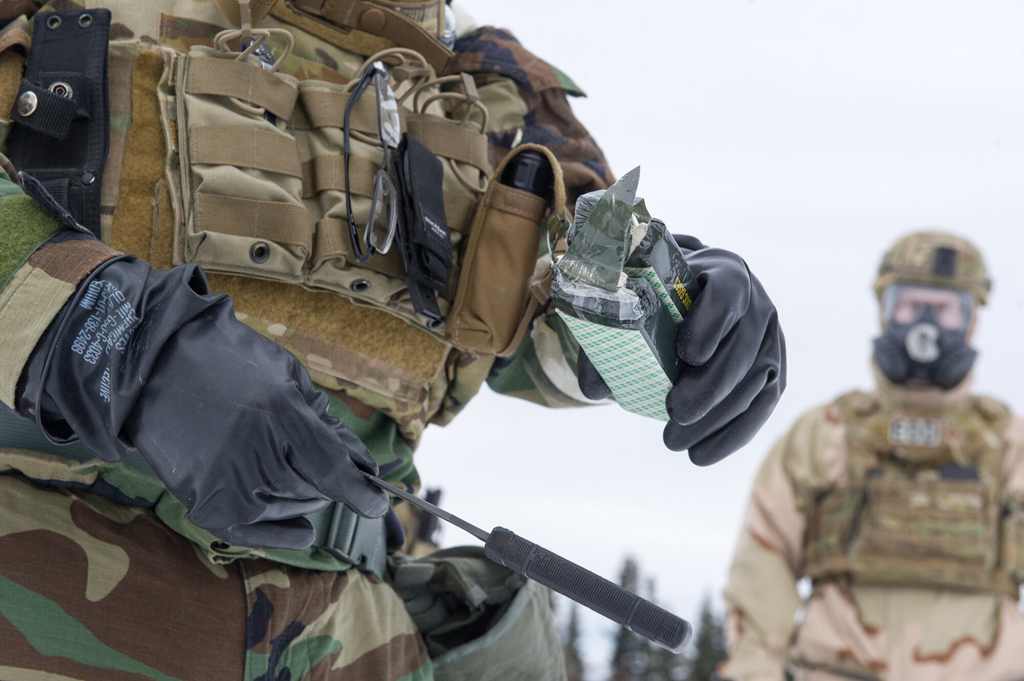 An Airman assigned to the 673d Civil Engineer Squadron, Explosives Ordinance Disposal Flight, prepares C-4 for a live-fire demolitions exercise in Mission Oriented Protective Posture 4 on Joint Base Elmendorf-Richardson, Alaska, Feb.14, 2018.  The Airmen were conducting EOD training in a simulated chemical weapons contaminated environment.