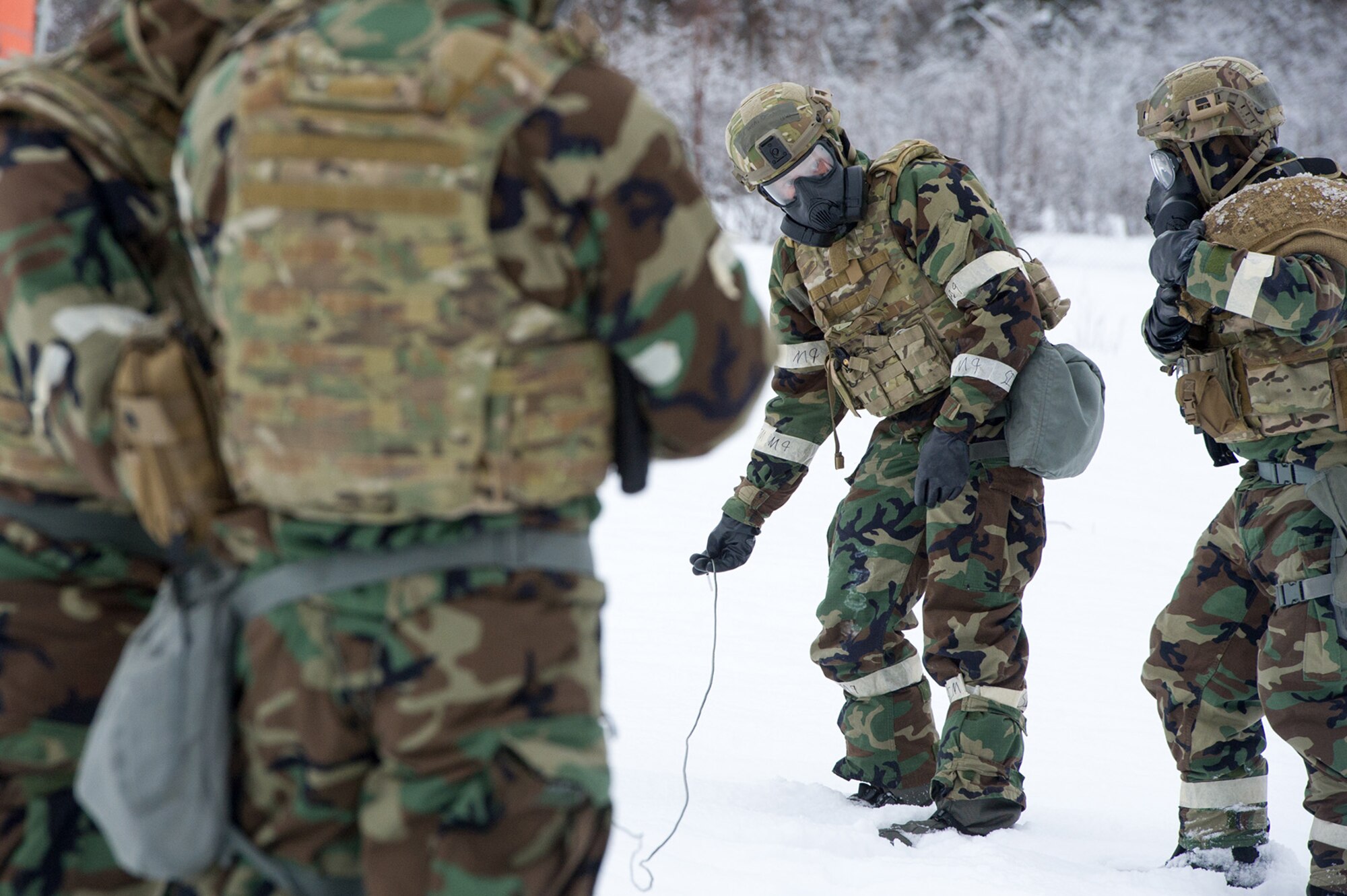 An Airman assigned to the 673d Civil Engineer Squadron, Explosives Ordinance Disposal Flight, prepares a blasting cap for a live-fire demolitions exercise in Mission Oriented Protective Posture 4 on Joint Base Elmendorf-Richardson, Alaska, Feb.14, 2018.  The Airmen were conducting EOD training in a simulated chemical weapons contaminated environment.