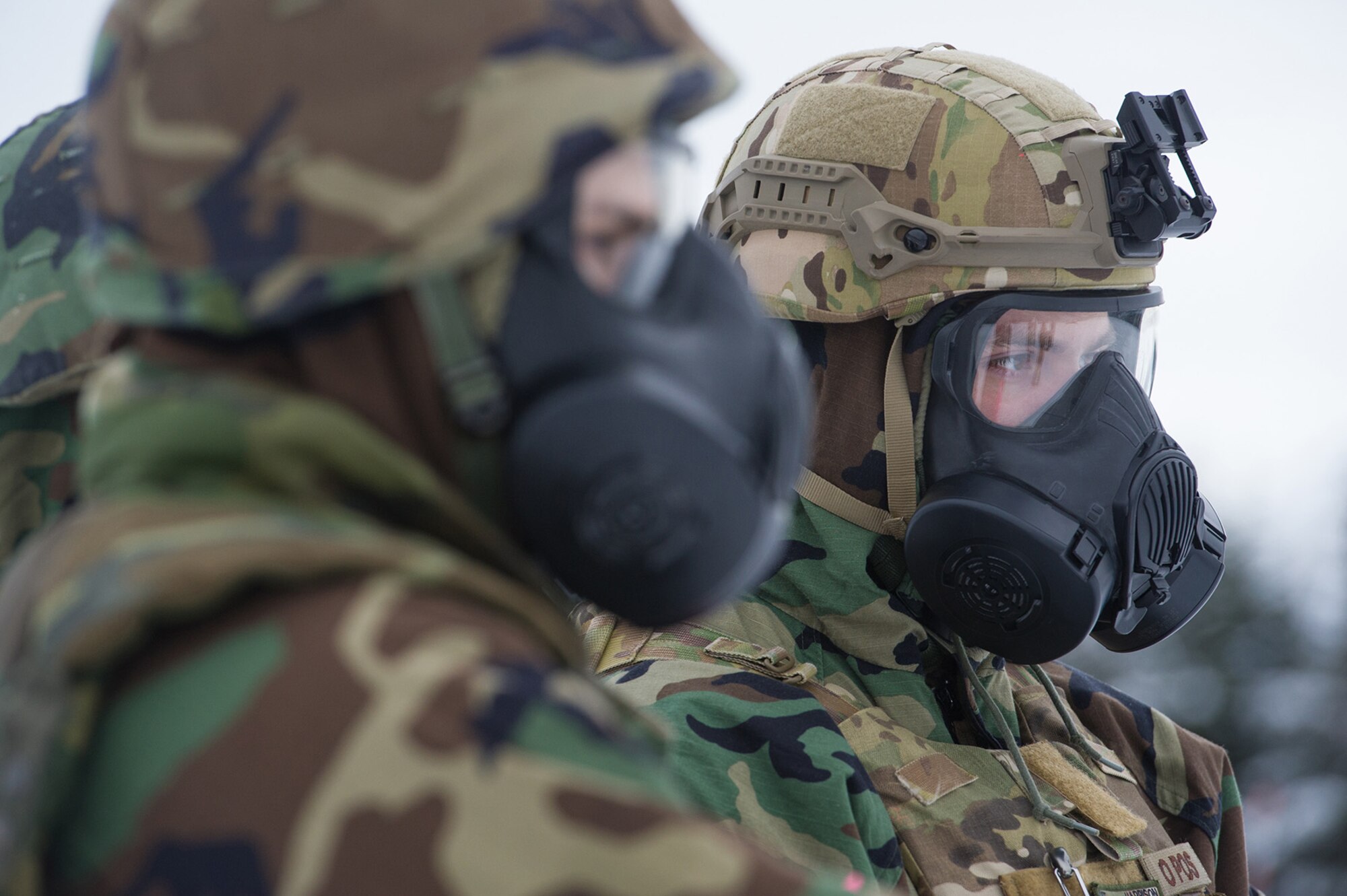 Air Force Capt. Justin Harrison observes Airmen assigned to the 673d Civil Engineer Squadron, Explosives Ordinance Disposal Flight, preparing charges for a live-fire demolitions exercise in Mission Oriented Protective Posture 4 on Joint Base Elmendorf-Richardson, Alaska, Feb.14, 2018.  The Airmen were conducting EOD training in a simulated chemical weapons contaminated environment.