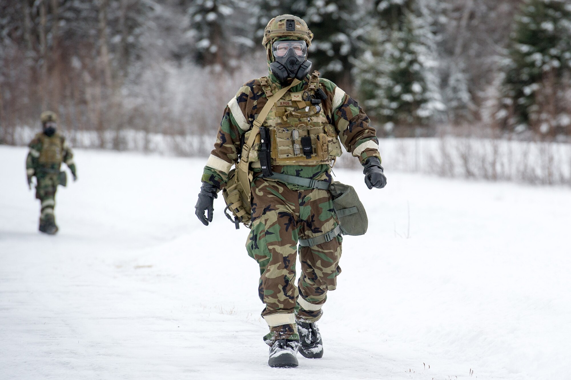 Senior Airman Michael Carlson, assigned to the 673d Civil Engineer Squadron, Explosives Ordinance Disposal Flight, walks of the range prior to conducting a live-fire demolitions exercise in Mission Oriented Protective Posture 4 on Joint Base Elmendorf-Richardson, Alaska, Feb.14, 2018.  The Airmen were conducting EOD training in a simulated chemical weapons contaminated environment.