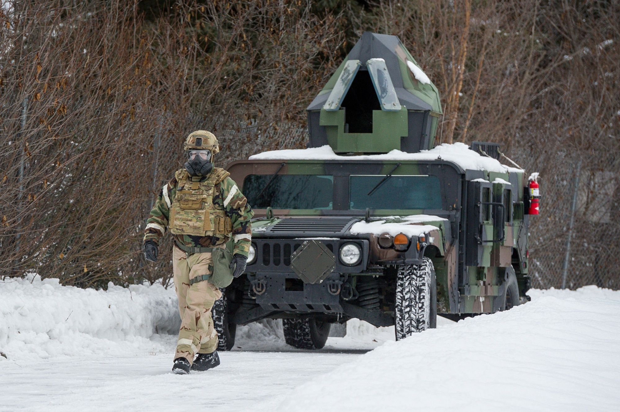 Senior Master Sgt. Ronald White, assigned to the 673d Civil Engineer Squadron, Explosives Ordinance Disposal Flight, walks in front of an armored HMMWV before observing his Airmen conducting a live-fire demolitions exercise in Mission Oriented Protective Posture 4 on Joint Base Elmendorf-Richardson, Alaska, Feb.14, 2018.  The Airmen were conducting EOD training in a simulated chemical weapons contaminated environment.